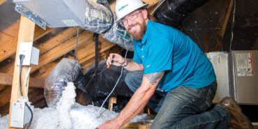 Craig Lay crawls into the attic to check the insulation.