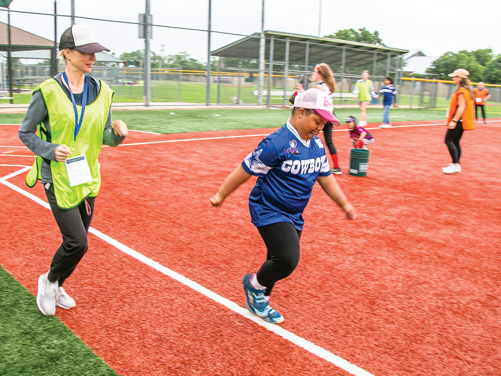 Andrea Martinez runs to first with her volunteer buddy.