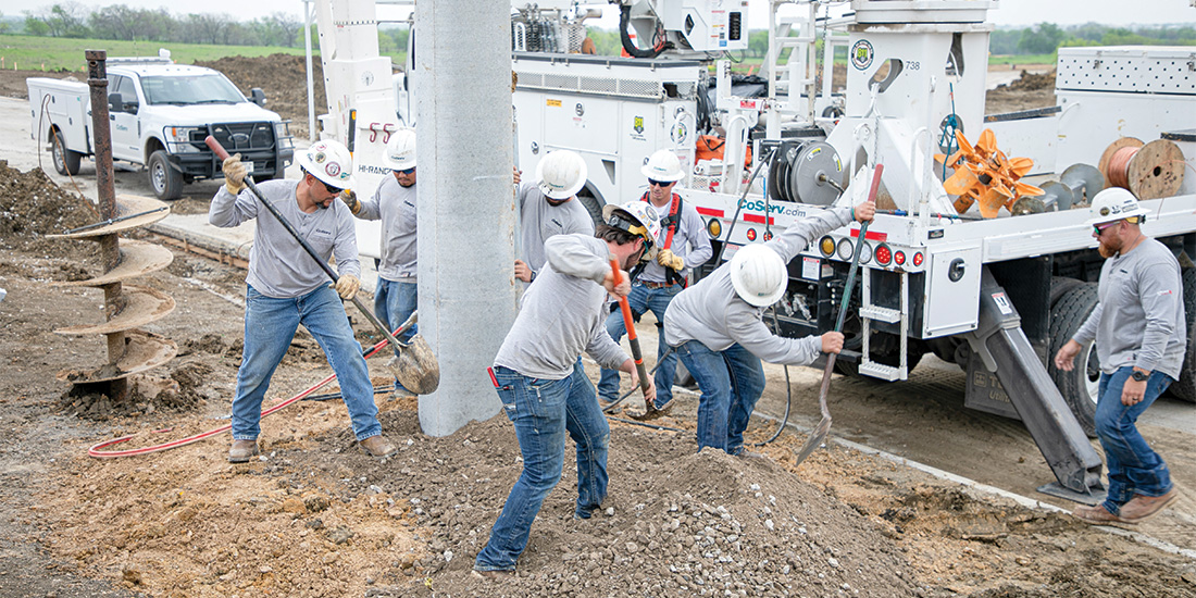 Once the pole is placed, linemen fill in the hole with a rock and dirt mixture and tamp it down. Photos by KEN OLTMANN