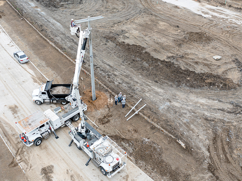 Linemen installing concrete poles in the far eastern Pilot Point area. Moberly Farms Neighborhood.