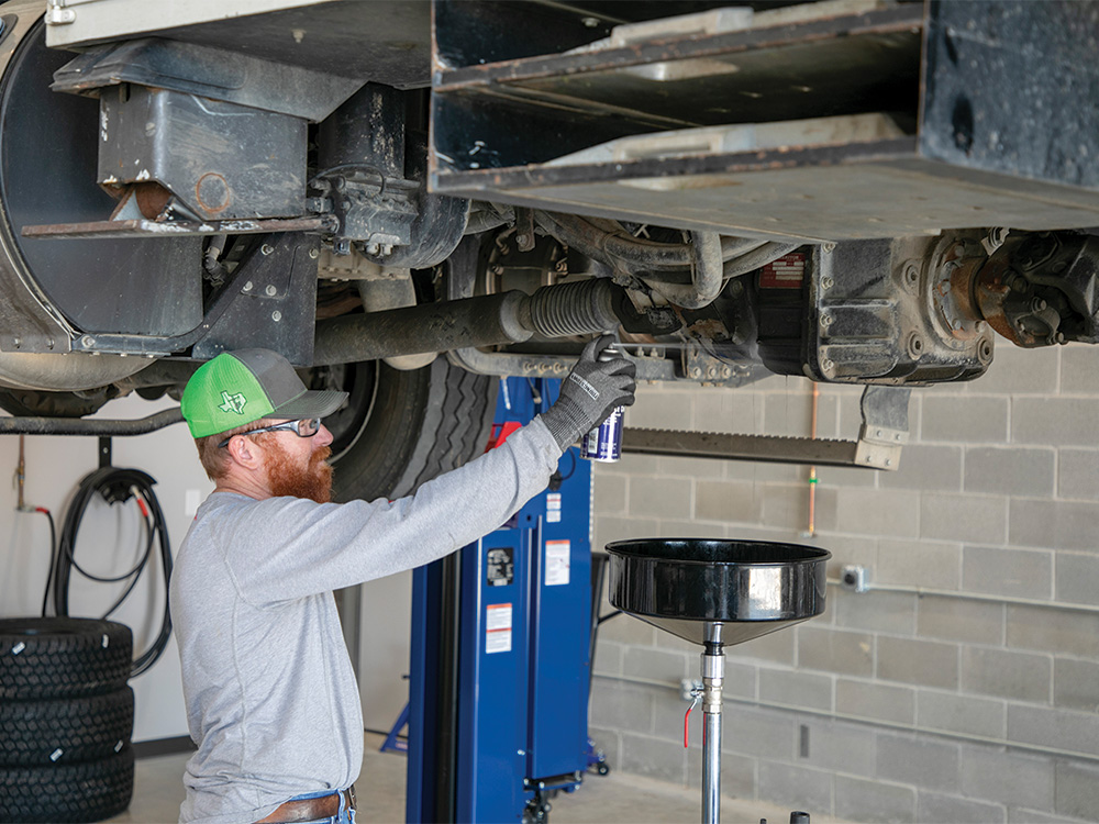 Aubrey Fortenberry checks the transfer case on a CoServ bucket truck.