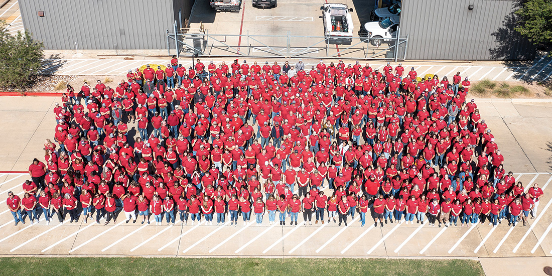 CoServ Employees stand together as "One" in a company photo.