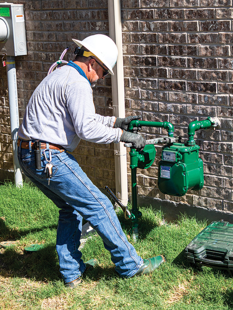 Tino Acosta, Gas Service Operations Technician installs a new gas meter 
in Lewisville.