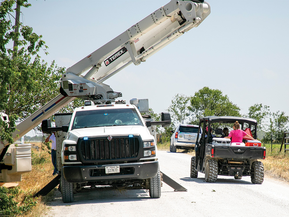 CoServ Linemen work to restore power while members of the community drive around offering water to those in need. Photo by BRIAN ELLEDGE